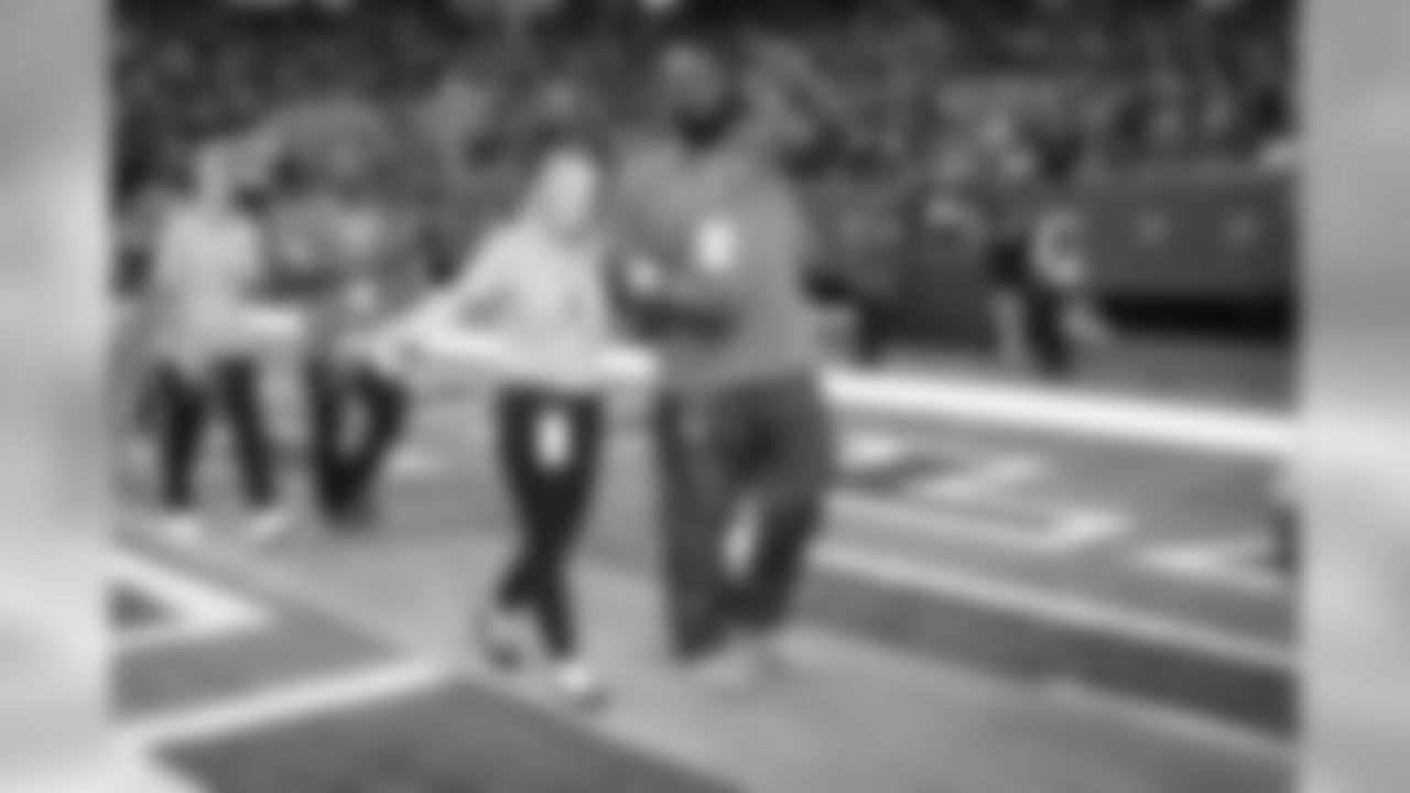 Breast cancer survivors received pink roses and were escorted out of the tunnel onto the field by Falcons alumni