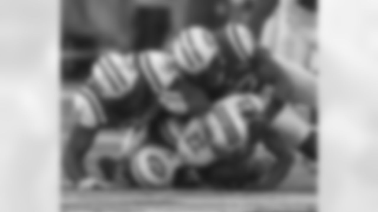 DE Muhammad Wilkerson (No. 96), LB Calvin Pace (No. 97) and LB Bryan Thomas (No. 58) bring down RB Reggie Bush in a gang tackle during a game last season.
