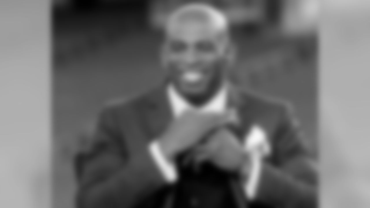 Broadcaster and Pro Football Hall of Fame defensive back Deion Sanders adjusts his tie as he sits on the sideline set before an NFL football game between the New England Patriots and Miami Dolphins, Thursday, Oct. 29, 2015, in Foxborough, Mass. (AP Photo/Bill Sikes)