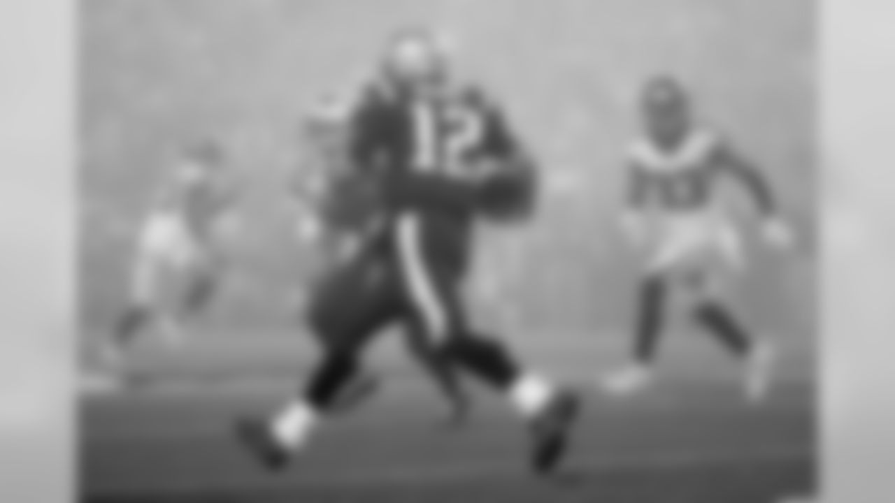 New England Patriots quarterback Tom Brady (12) runs in the fog as Atlanta Falcons defensive back Blidi Wreh-Wilson (33) pursues during the second half of an NFL football game, Sunday, Oct. 22, 2017, in Foxborough, Mass. (AP Photo/Steven Senne)