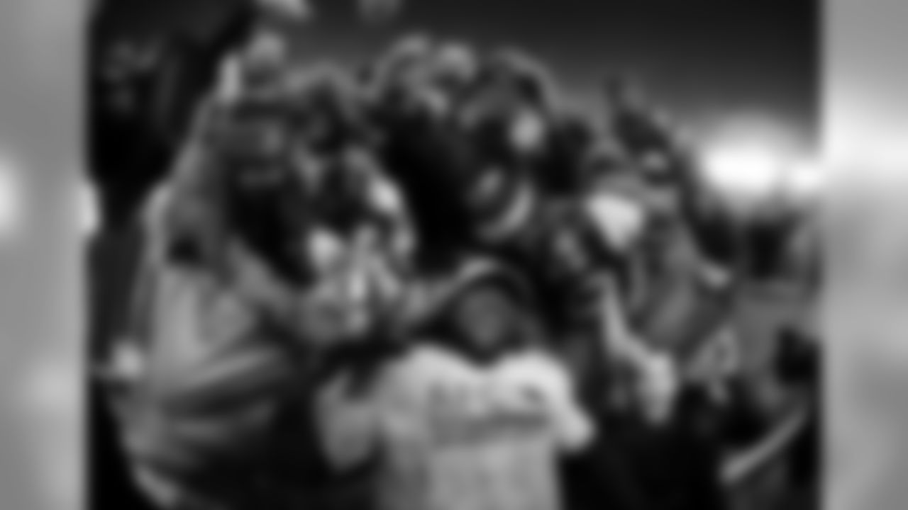 New England Patriots running back LeGarrette Blount holds the AFC championship trophy surrounded by fans after the AFC championship NFL football game, Sunday, Jan. 22, 2017, in Foxborough, Mass. The Patriots defeated the the Pittsburgh Steelers 36-17 to advance to the Super Bowl. (AP Photo/Matt Slocum)