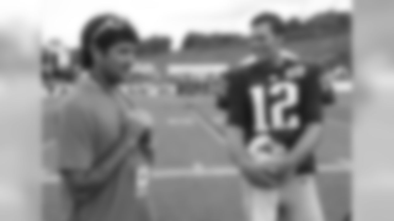 New England Patriots quarterback Tom Brady (12) talks with pro golfer Bubba Watson after a joint practice between the Patriots and New Orleans Saints at the Saint's NFL football training camp in White Sulphur Springs, W.Va., Thursday, Aug. 20, 2015. (AP Photo/Steve Helber)