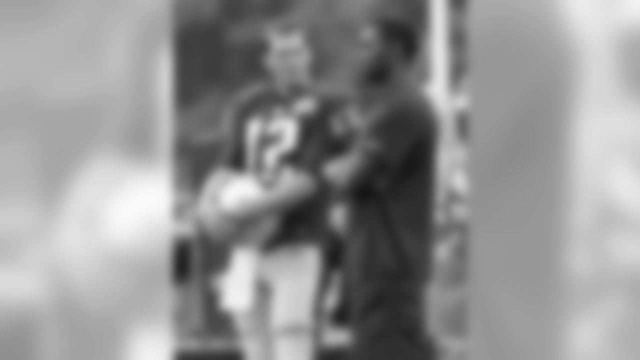 New England Patriots quarterback Tom Brady (12) talks with former wide receiver Randy Moss, right, during a joint practice between the Patriots and New Orleans Saints at the Saint's NFL football training camp in White Sulphur Springs, W.Va., Thursday, Aug. 20, 2015. (AP Photo/Steve Helber)