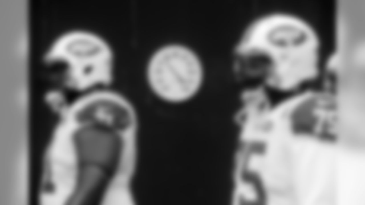 A thermometer in the runway displays a temperature in the teens as New York Jets tackle Ben Ijalana (71) and defensive end Xavier Cooper (75) take the field for an NFL football game against the New England Patriots, Sunday, Dec. 31, 2017, in Foxborough, Mass. (AP Photo/Steven Senne)