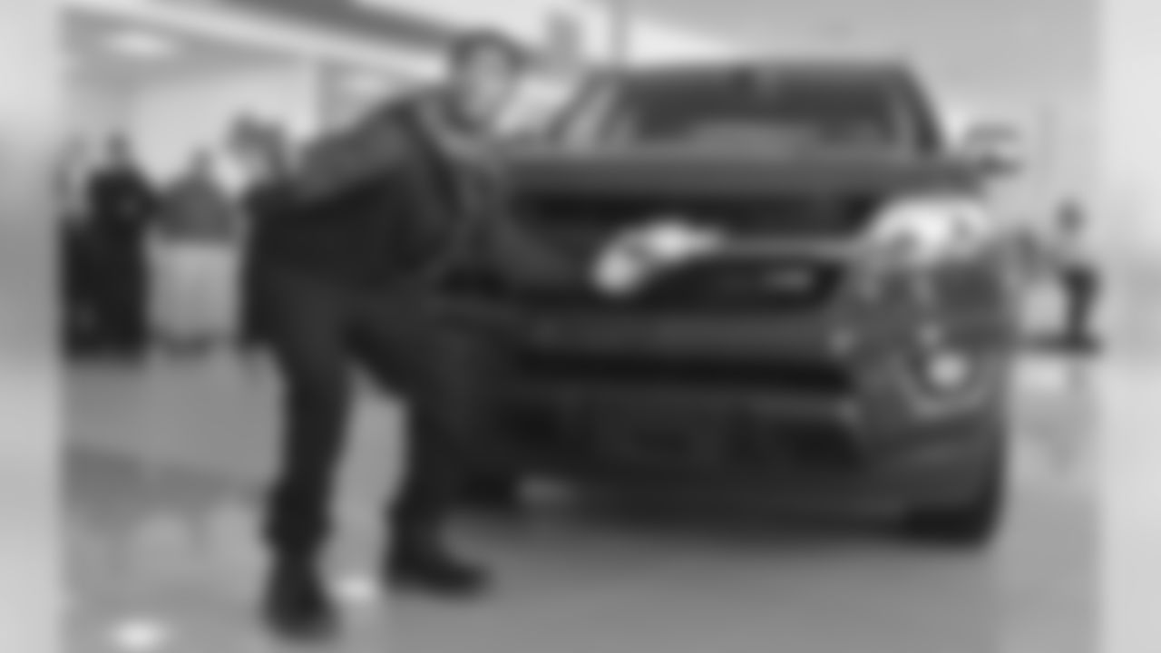 New England Patriots cornerback Malcolm Butler poses with a Chevrolet pickup truck he was presented Tuesday, Feb. 10, 2015, at a dealership in Norwood, Mass. The truck was intended to go to Patriots quarterback Tom Brady as Super Bowl Most Valuable Player. But Brady and the automaker determined that Butler should receive it in recognition for his game-saving interception that clinched the team's Super Bowl XLIX victory.