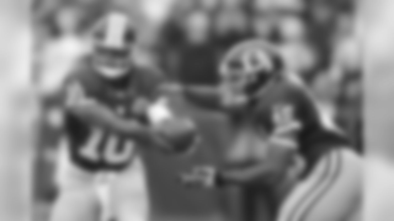 Redskins QB Robert Griffin III hands the ball off to RB Alfred Morris in the first half.