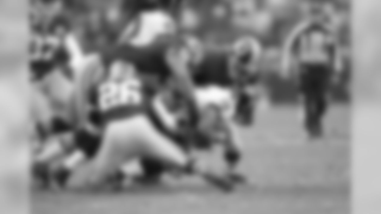 Multiple Redskin defenders tackle a Ravens ball carrier.
