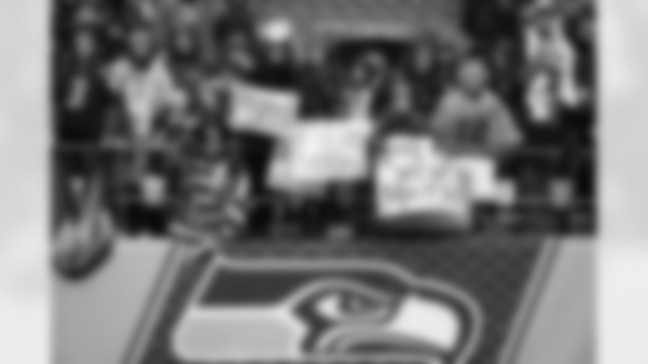 Out near the field, early-arriving fans support their favorite players as they wait for them to run on to the field.