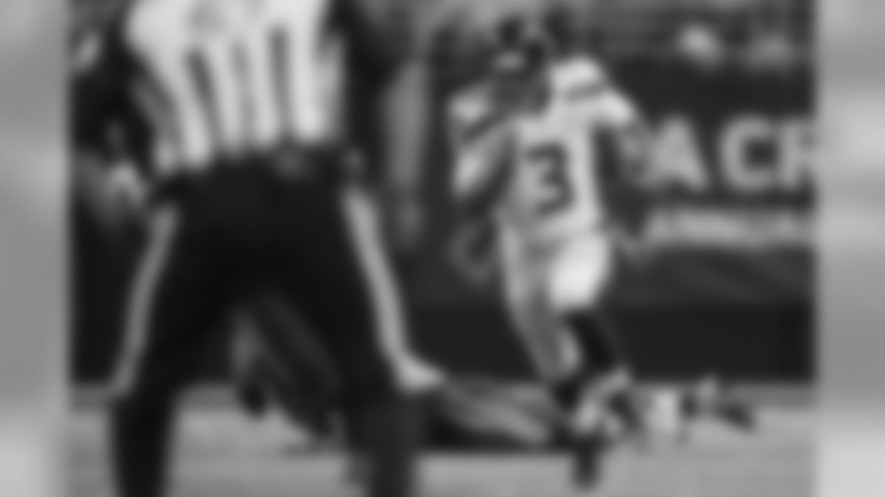Russell Wilson leaves the Rams in his wake as he runs up the left side for a 52-yard gain. Wilson became the first player in NFL history to pass for over 300 yards and rush for over 100 yards in a single game.