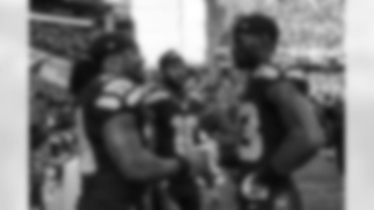 Running back Marshawn Lynch talks to young receivers Ricardo Lockette and Paul Richardson on the Seahawks sideline just before kickoff.