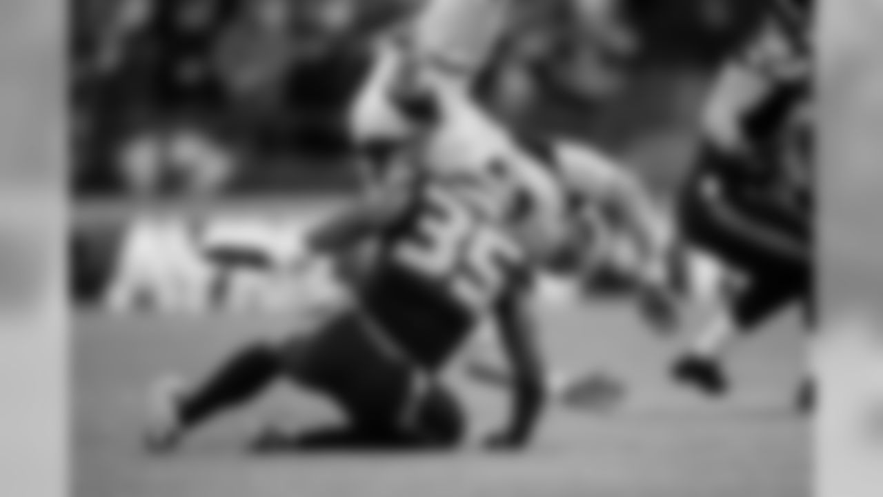 Arizona punter Drew Butler is upended after his punt was blocked by Seattle's DeShawn Shead.