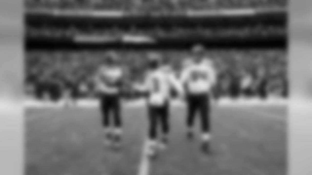 Quarterback Russell Wilson is flanked by Kevin Pierre-Louis and Kevin Williams as they head to midfield for the pregame coin toss.
