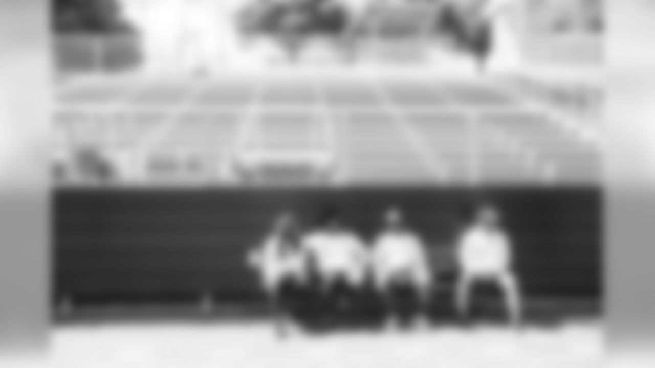 Defensive players Richard Sherman, Michael Bennett, Cliff Avril and Bruce Irvin have a seat on a bench while waiting for the offense to finish their part of walk-thru.