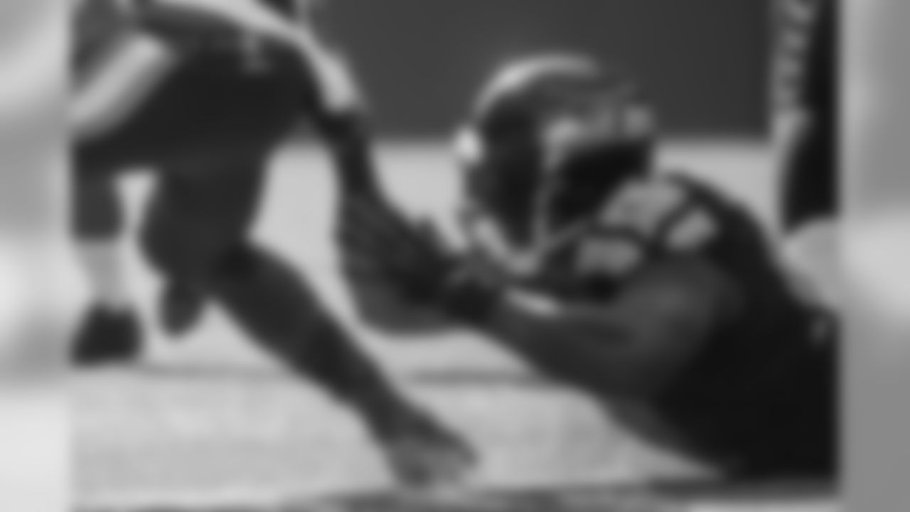 Seattle's Chris Clemons manages to slow down Tennessee's Chris Johnson by grabbing a piece of his jersey.