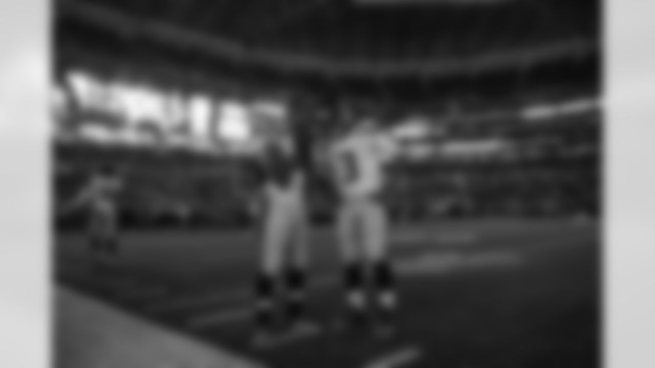 Receiver Doug Baldwin and quarterback Russell Wilson confer on the field during pregame with the lights darkened in the dome for the introduction of the Rams.