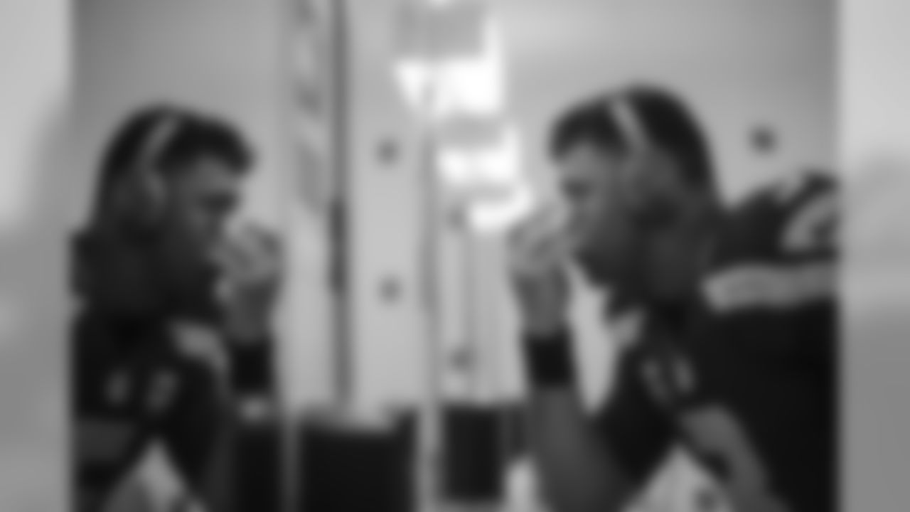 Quarterback Russell Wilson applies his eye black in the locker room before the game.