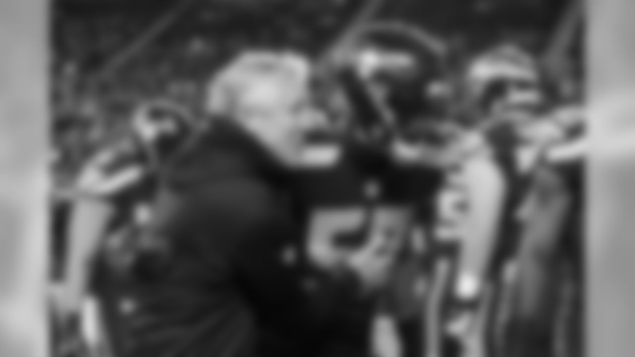 Head coach Pete Carroll greets linebacker Mike Morgan in his first game back from injury as the team took the field for pregame warmups.