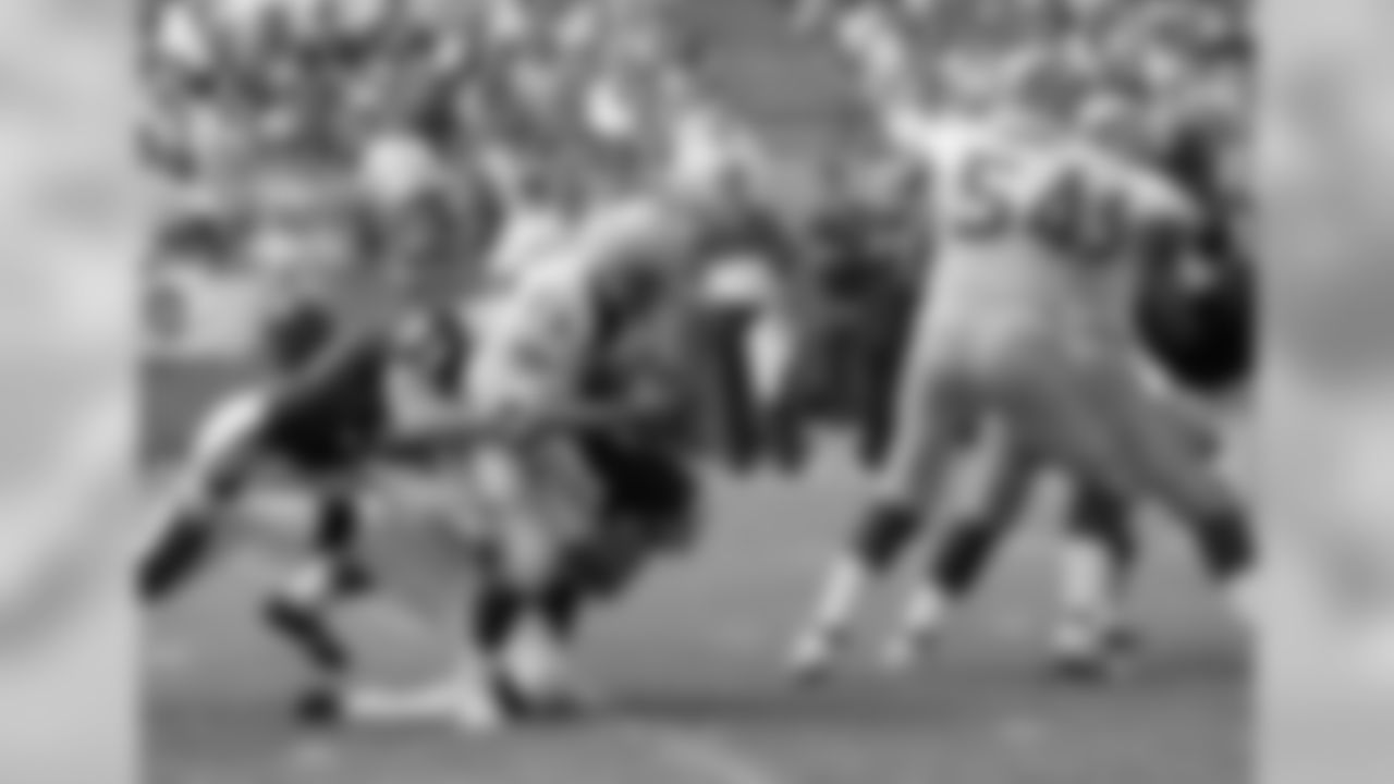 Seattle Seahawks quarterback Dave Krieg (17) falls to the ground after being sacked for a 9-yard loss by Chicago Bears defensemen Trace Armstrong, left, and Dan Hampton, on ground right, in the second quarter in Chicago, Sept. 9, 1990. (AP Photo/Charles Bennett)
