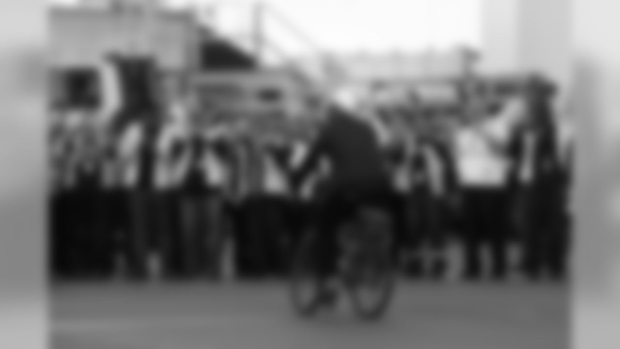 Michael Bennett once again borrowed a bicycle from police officers, and this time rode along the tarmac to salute airport workers gathered to send the team off to Arizona.