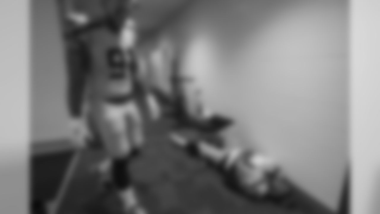 In the visitor's locker room, Cassius Marsh returns from applying his facial markings while B.J. Daniels lies down and focuses on his pregame routine.