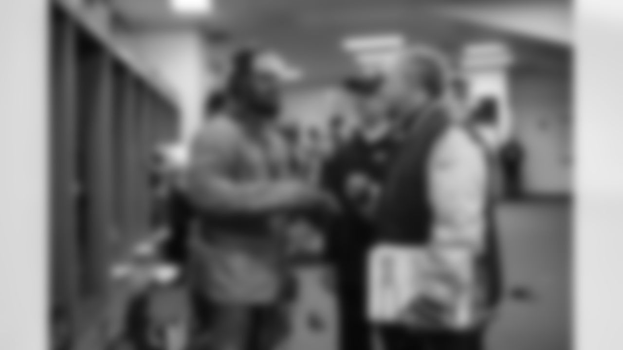 In the locker room postgame, running back Marshawn Lynch talks to quarterbacks coach Carl Smith before heading out.