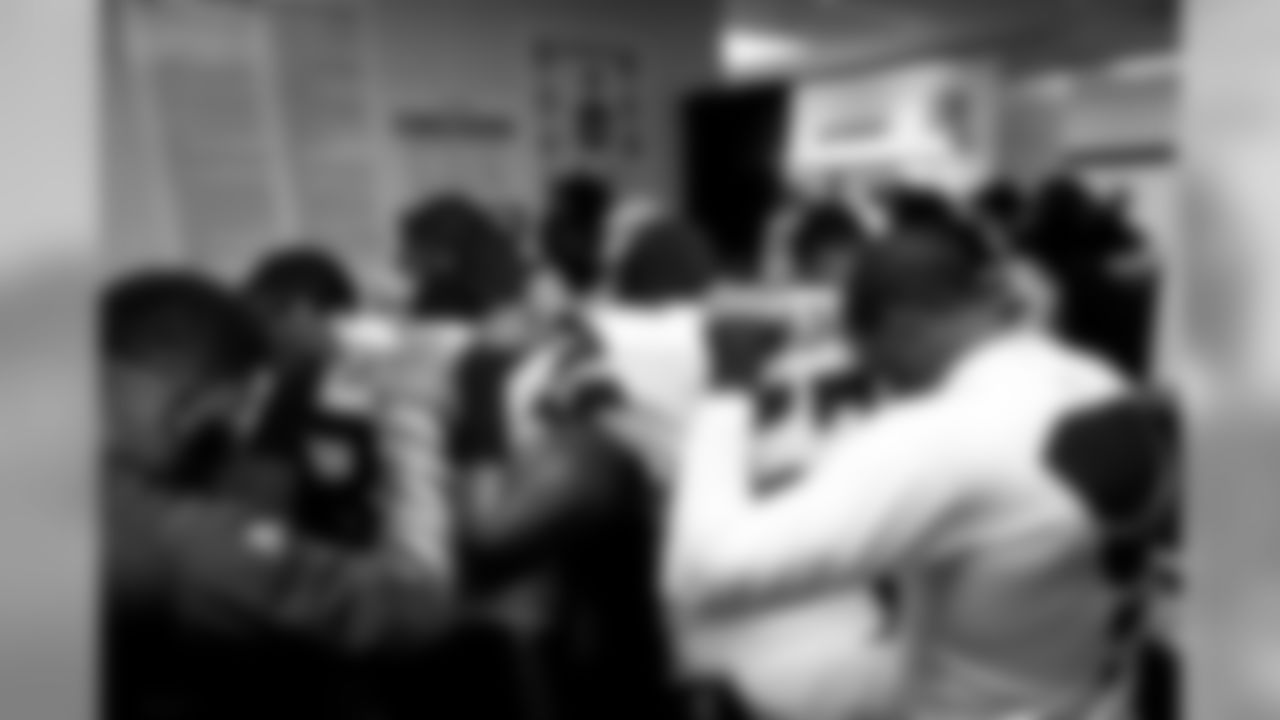 The team crowded together near the showers for their pregame prayers, spilling out into the locker room area.
