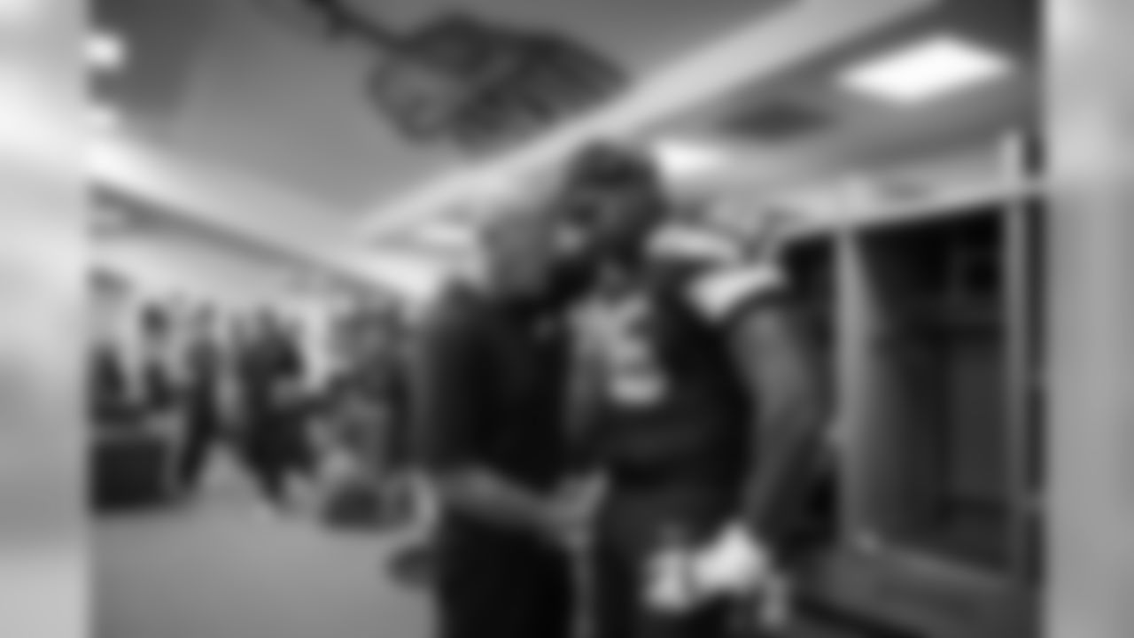 In the locker room after the game, offensive line coach Tom Cable has a quiet moment with starting left tackle Russell Okung.
