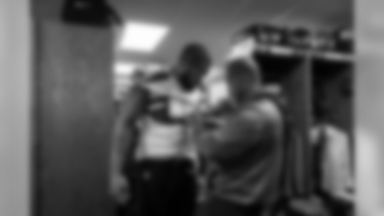 Michael Bennett gets strapped up for the game with the help of team staffer Rick Rainwater.