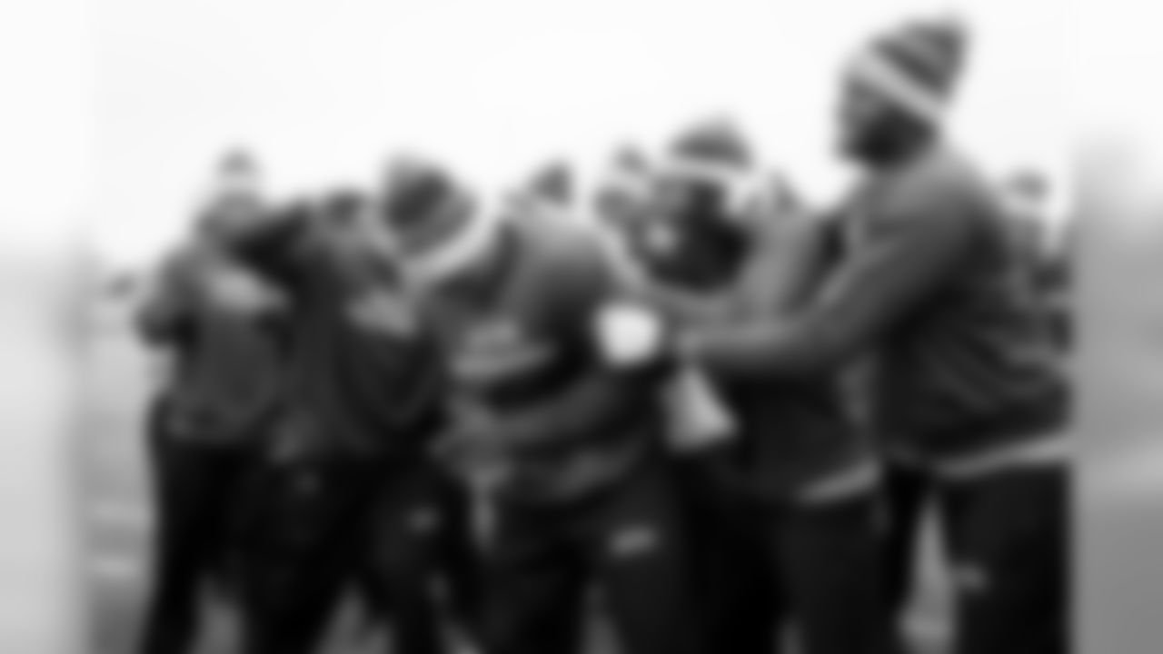 Defensive players including Richard Sherman and Mike Morgan congratulate teammate Kevin Pierre-Louis after it was announced he would be a game captain for the contest against the Chiefs.
