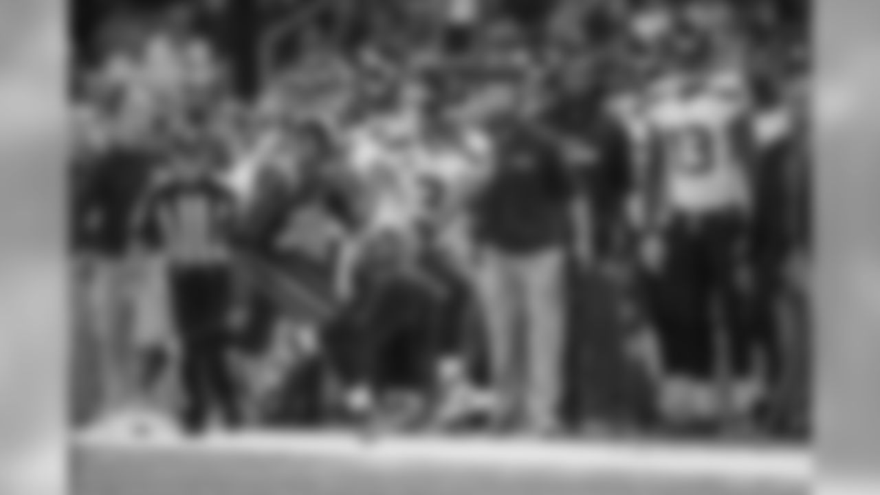 Quarterback Russell Wilson scrambles up the sideline in front of the Seahawks bench for a first down.