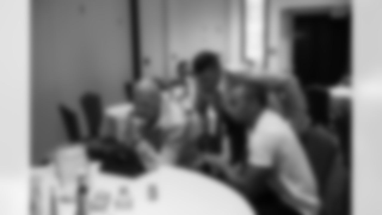 Offensive line coach Tom Cable, quarterback Russell Wilson and receiver Doug Baldwin review game tape in the dining room of the team hotel as the clock neared 2:00 in the morning.