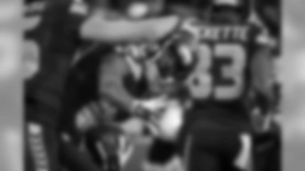 A very happy Paul Richardson peeks out from the congratulations of teammate Jermaine Kearse and looks to shake the hand of running back Marshawn Lynch.