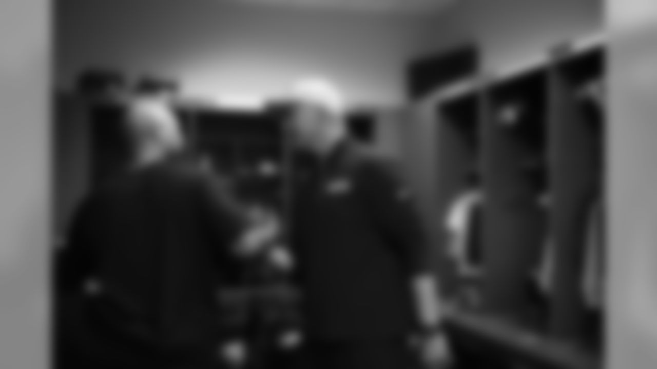 Coordinators Kris Richard (defense) and Darrell Bevell (offense) share congratulations in the victorious Seahawks locker room after the game.