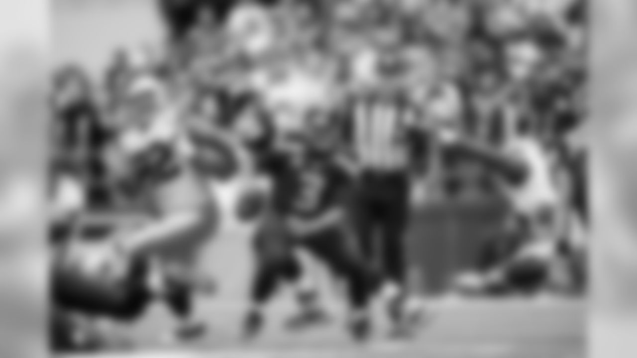 Russell Wilson scrambles to avoid pressure by the Cowboys defense.