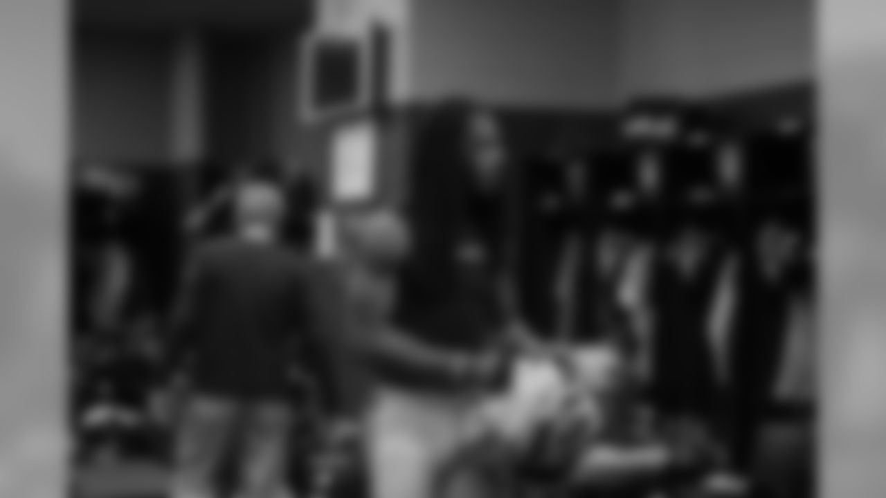 In the locker room, cornerback Richard Sherman prepares to put his pads on.