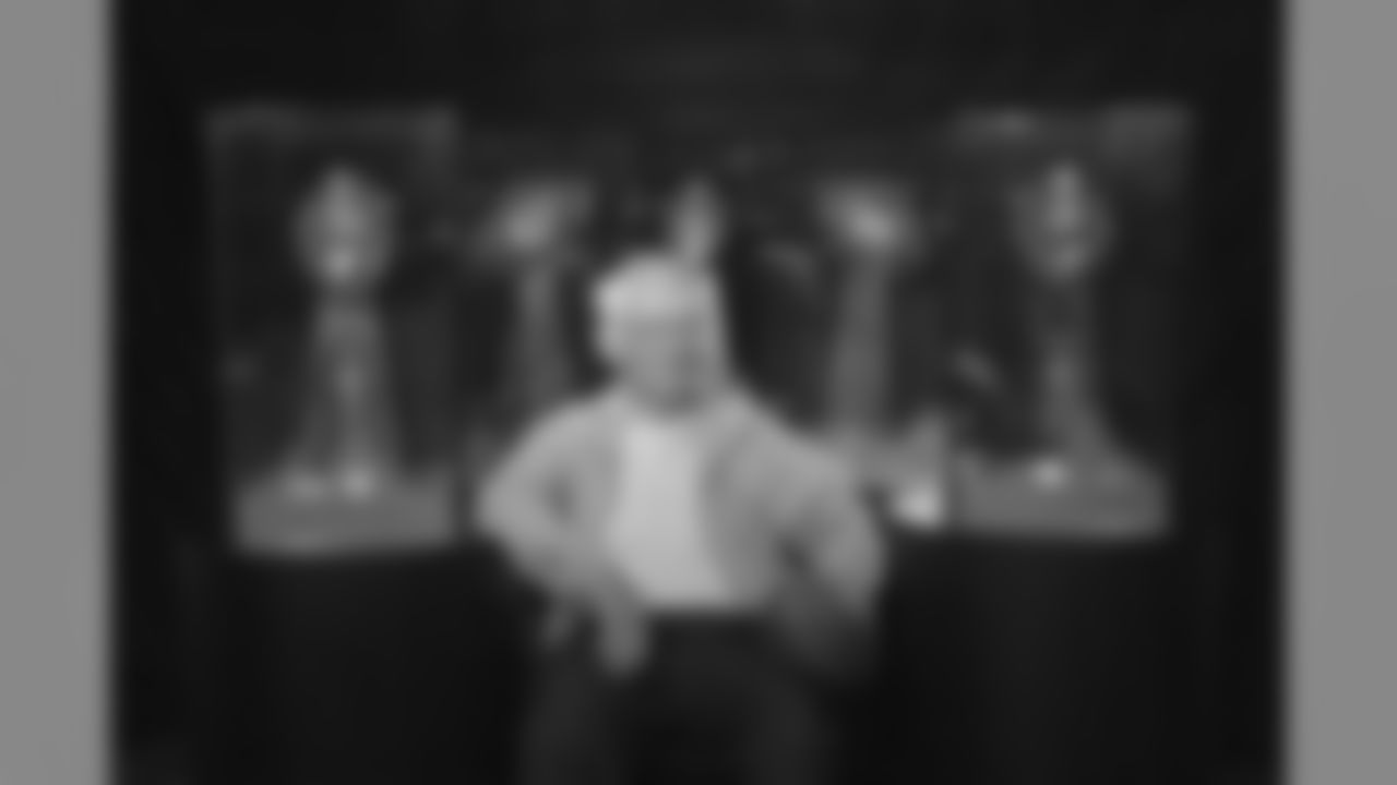 Dan Rooney poses with five Lombardi trophies behind him.