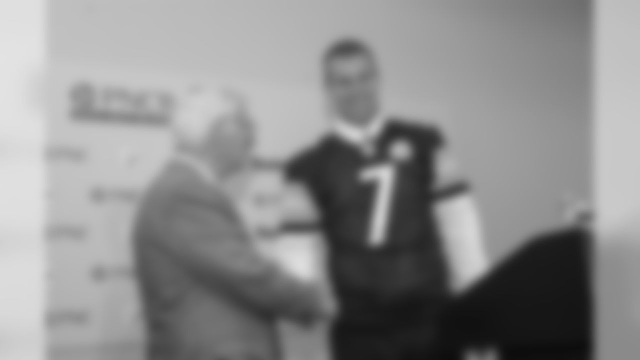 Dan Rooney shakes hands with the 2004 1st Round Draft pick Ben Roethlisberger at a press conference presenting him his jersey.