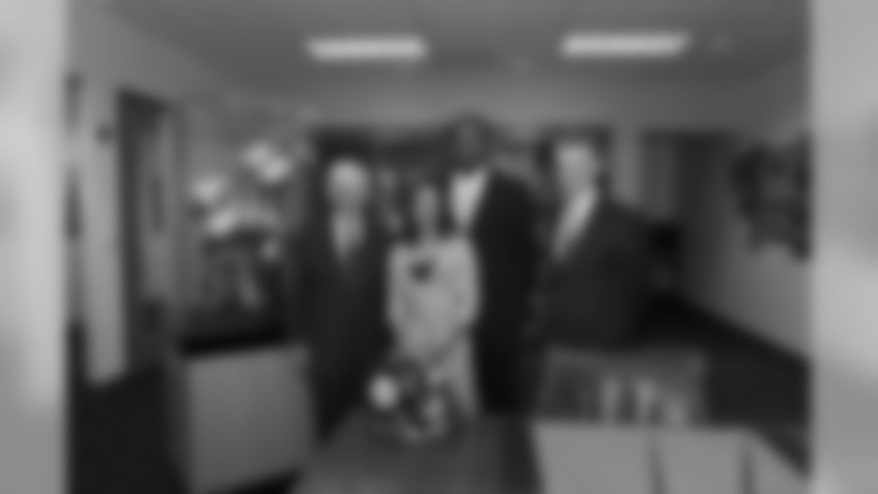 Dan Rooney and Art Rooney II pose for a photo with Mike and Kiya Tomlin after signing Mike Tomlin to the Steelers as Head Coach.