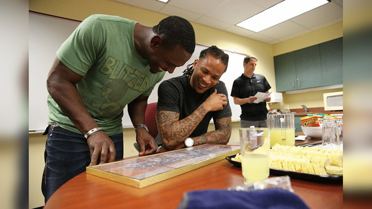 Lito Sheppard and Jabar Gaffney look at a high school class photo before the event