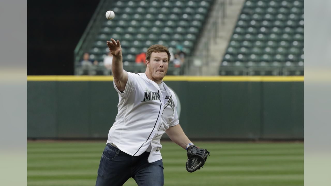 NFL football Seattle Seahawks' Ethan Pocic throws out the ceremonial first pitch for a baseball game between the Seattle Mariners and the Oakland Athletics, Thursday, May 3, 2018, in Seattle. (AP Photo/Ted S. Warren)