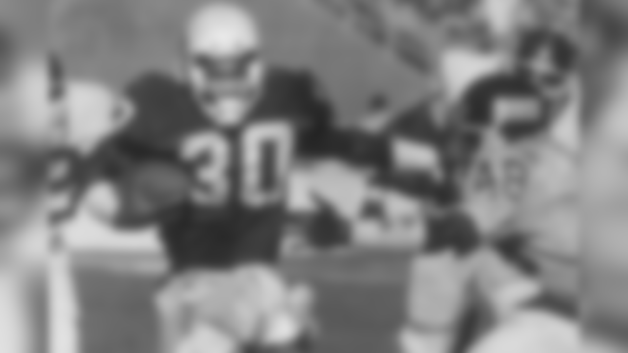 RB Stump Mitchell stiff-arms New York's Kenny Hill in 1988