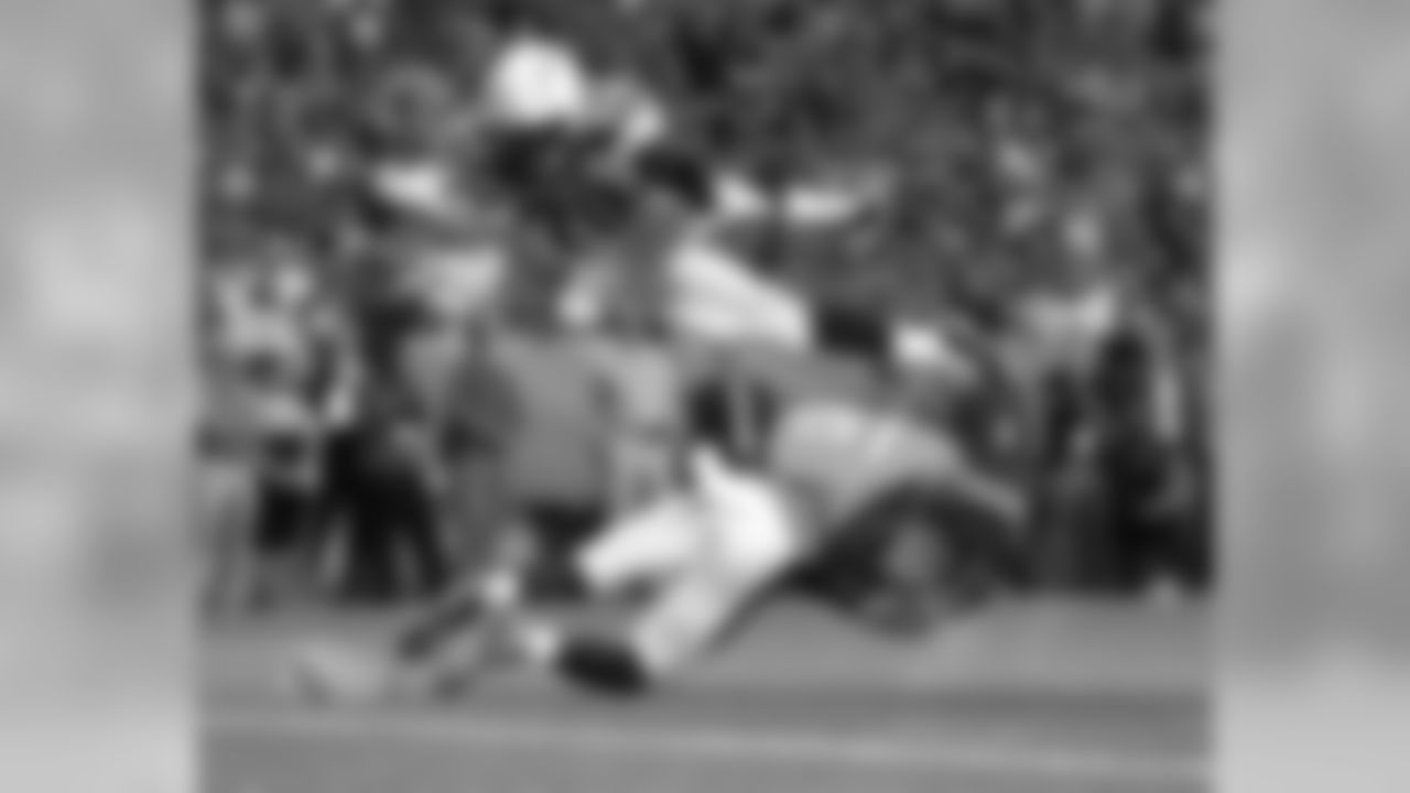 Los Angeles Chargers running back Melvin Gordon (28) dives over Denver Broncos strong safety Justin Simmons (31) for a touchdown during the first half of an NFL football game, Monday, Sept. 11, 2017, in Denver. (AP Photo/Jack Dempsey)