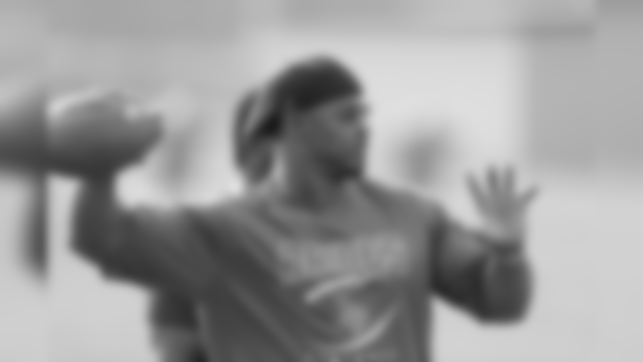 Brian Dawkins throws a football to a Raines player during practice