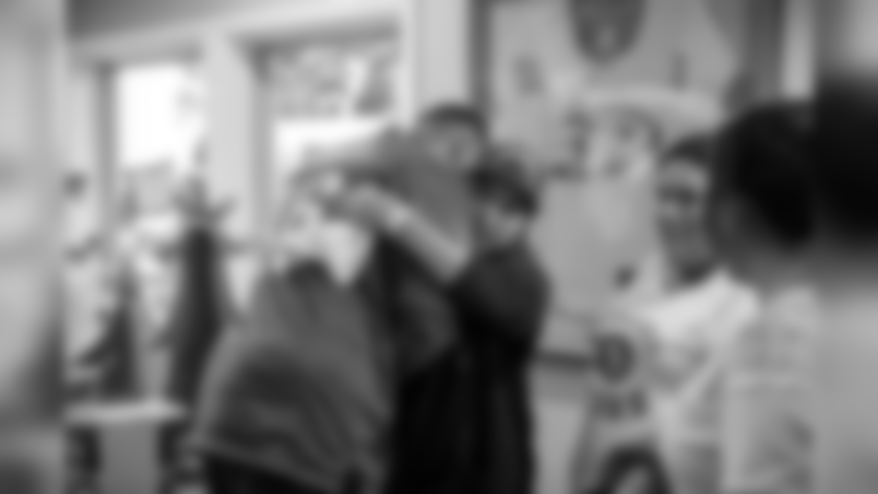 DE Derek Barnett hugging one of the children.