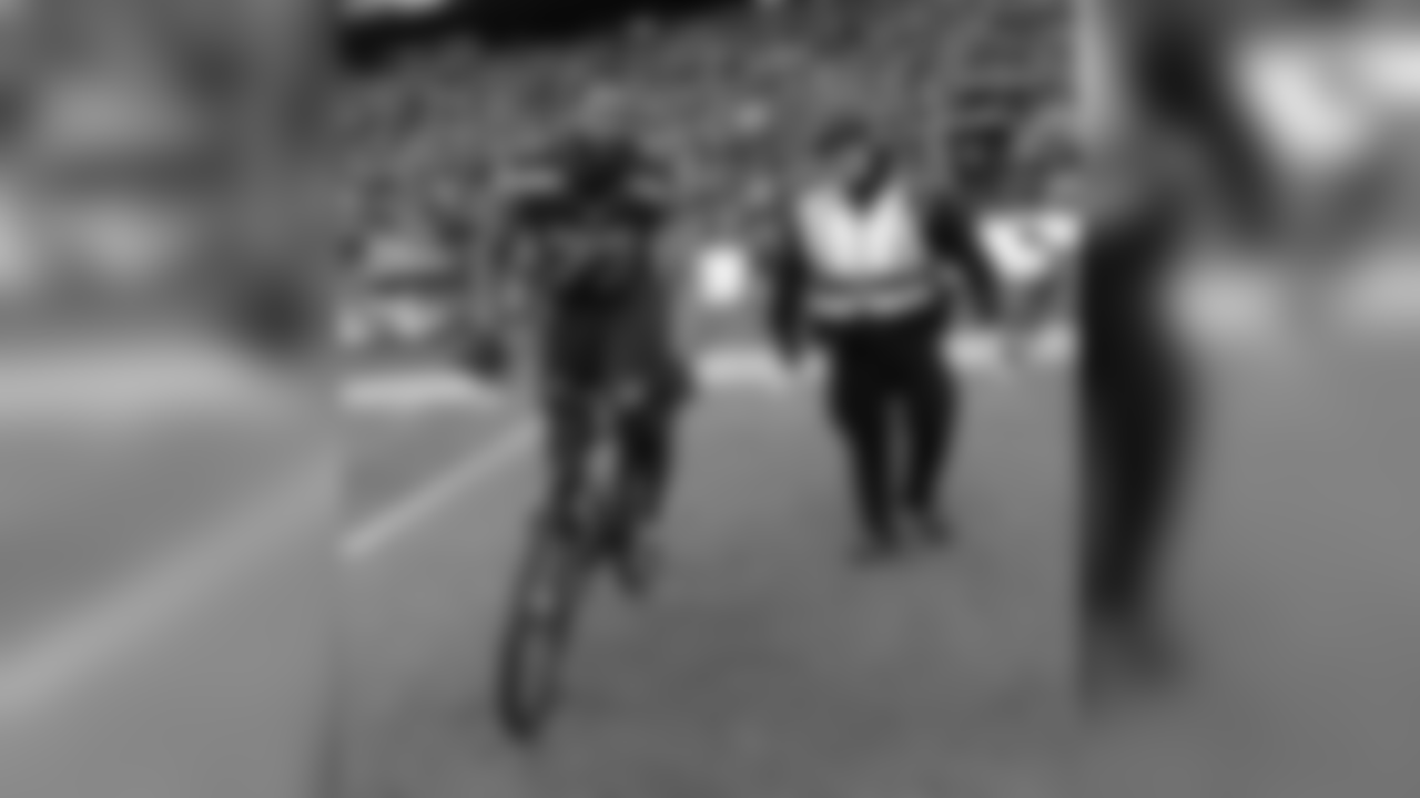 Seattle Seahawks' Michael Bennett borrows a police officers bike after overtime of the NFL football NFC Championship game against the Green Bay Packers Sunday, Jan. 18, 2015, in Seattle. The Seahawks won 28-22 to advance to Super Bowl XLIX. (AP Photo/David J. Phillip)