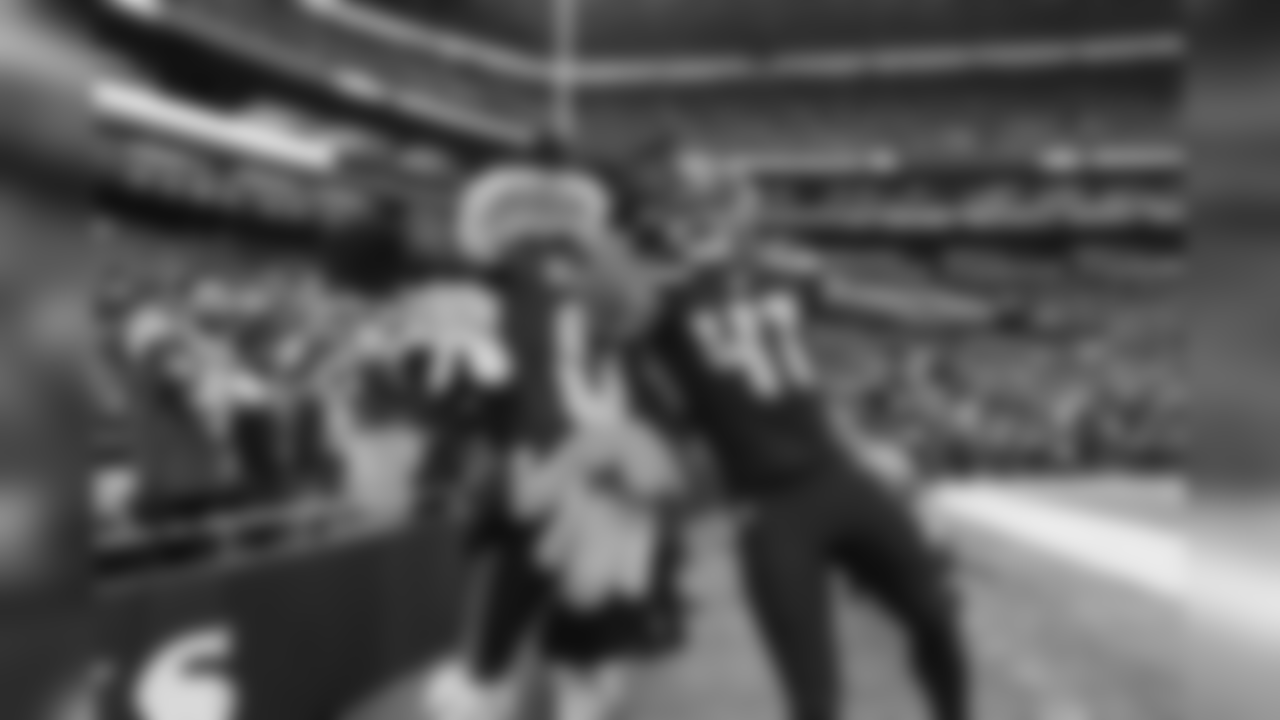 Seahawks special teamer George Farmer leaps with Seahawks mascot Blitz after running downfield on a kickoff.