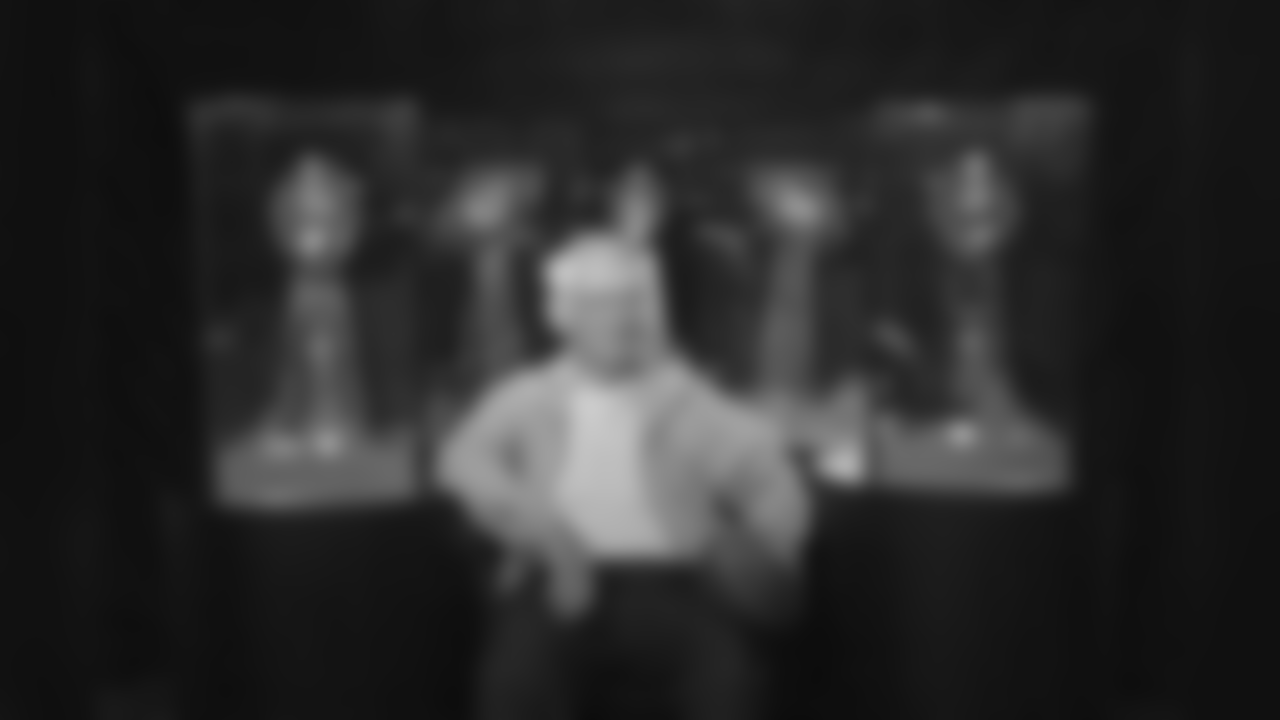 Dan Rooney poses with five Lombardi trophies behind him.