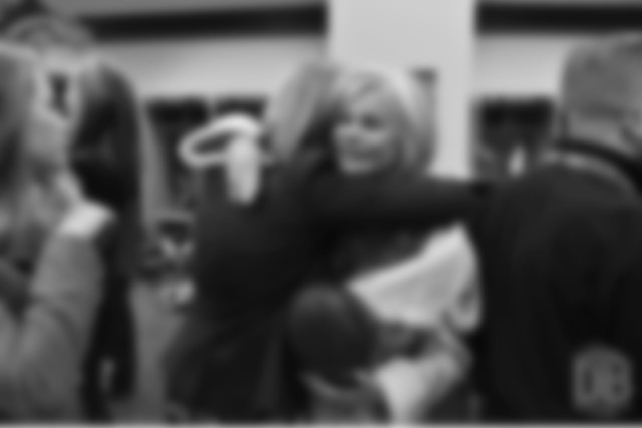 Annabel Bowlen holds the game ball she received from head coach Gary Kubiak as she hugs her daughter Brittany postgame in the locker room after Denver defeated the Packers on Nov. 1, 2015. Mrs. Bowlen had represented her husband, Broncos Owner Pat Bowlen, during the day's Ring of Fame induction festivities and gave a speech on his behalf at halftime.