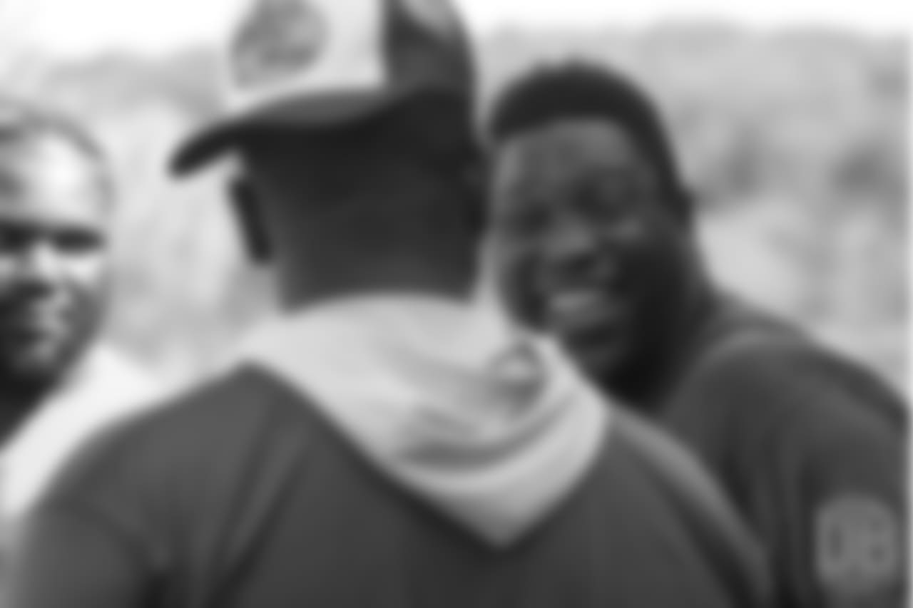 Warren Sapp shares a laugh with two of the defensive linemen at the on-field portion of Von Miller's Pass Rush Summit, which included hands-on instruction and drills, on June 28, 2018.