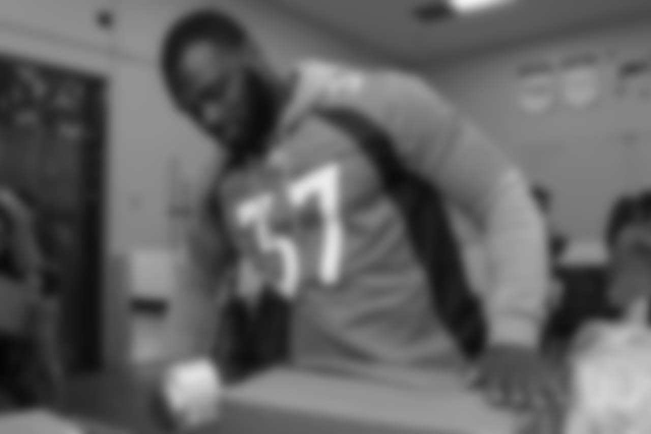 Running back Royce Freeman (37) tapes a food package shut at the Food Bank of the Rockies at the Broncos' third annual Rookie Community Service Day on June 11, 2018.